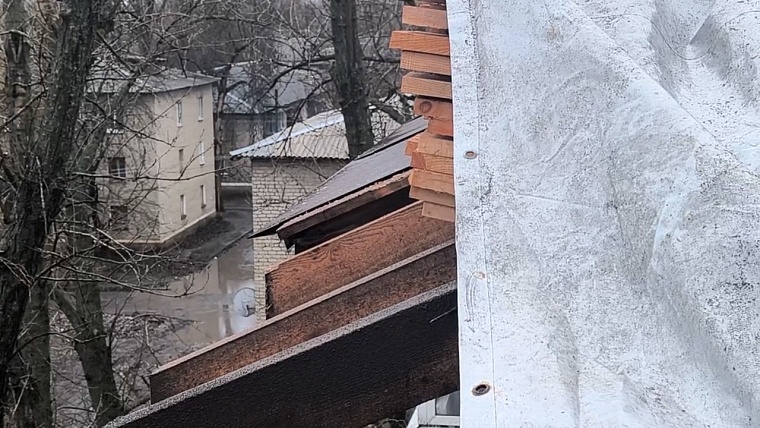Тюменские строители монтируют водосточную систему на доме в Суходольске